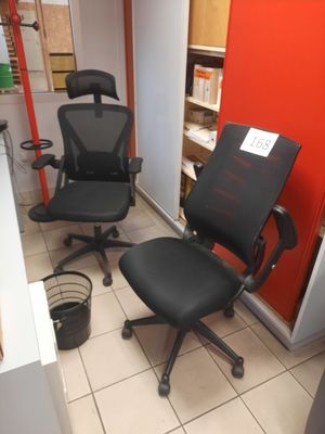 two black office chairs in a room with a red wall