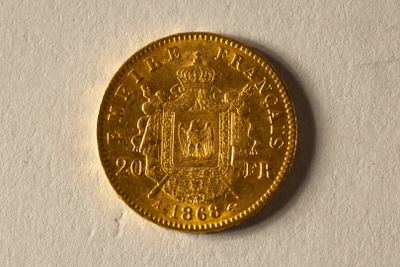 l'image d'une pièce d'or posée sur une surface blanche