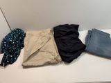 three pairs of pants are lined up on a white shelf