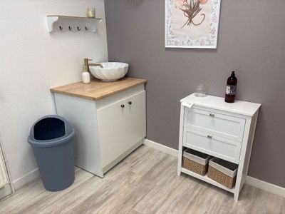 a bathroom with a sink and a trash can in it