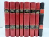 six livres en cuir rouge alignés sur une surface blanche