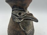 un petit vase orné d'une tête d'oiseau