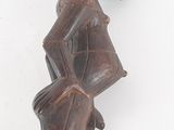 an image of a wooden statue of a man holding a bag