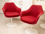 deux chaises rouges dans une pièce où se trouve une table blanche