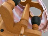 a wooden spinning machine with a pink blanket on it
