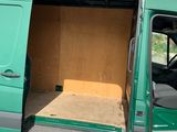 a green van with its doors open in a parking lot
