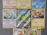 Plusieurs cartes Pokémon sont disposées sur une table devant un réfrigérateur.