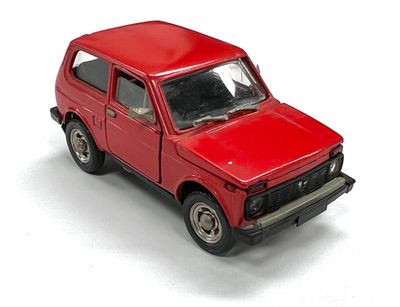 un camion jouet rouge posé sur une surface blanche