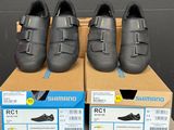 Trois paires de chaussures Shimano sont exposées dans une boîte