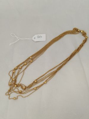 a gold necklace with three strands of gold beads on a white background