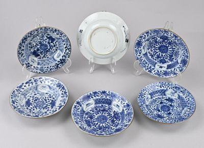 Plusieurs assiettes et bols bleus et blancs sont disposés en cercle