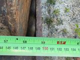 a measuring tape on a piece of wood next to a piece of metal