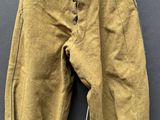 un vieux pantalon suspendu à un cintre accroché au mur