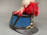 a bird sitting on top of a hat with feathers