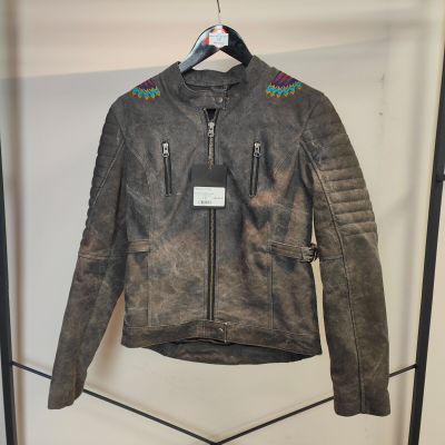 La veste en cuir est suspendue à un cintre dans un magasin de vêtements.