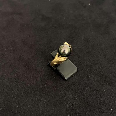 un petit anneau noir et doré sur une surface noire