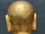 a statue of a man with a gold head and neck