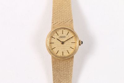une image d'un gros plan d'une montre-bracelet sur une surface blanche