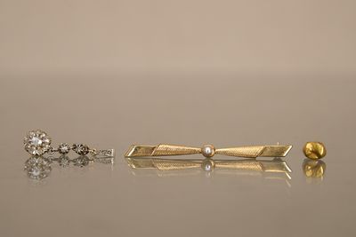 trois types différents de piercings aux oreilles sur une surface réfléchissante