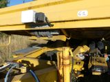 a large yellow crane that is sitting in the grass