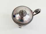 an antique silver plated teapot with a handle on a white background