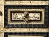a black and gold chest of drawers with pictures on it