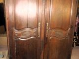 une grande armoire en bois dans le coin d'une pièce
