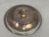 a silver plate with a gold lid on a table
