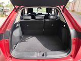 the back of a red car with its trunk open on the street