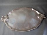 a silver tray with a handle and handles on a table