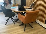 une femme assise à une table, un ordinateur portable posé devant elle