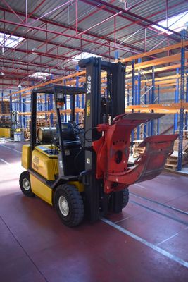 a forklift in a warehouse with pallets in the background