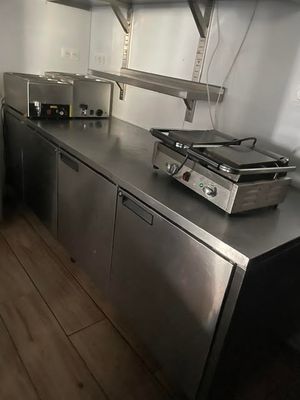 stainless steel counter top in a commercial kitchen with a stove and oven