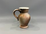 un gros plan d'un petit vase marron posé sur une table