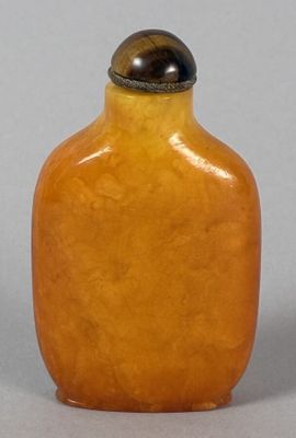 yellow glass snuff bottle with a tiger eye on the top