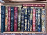 many old books in a wooden box on a table