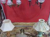 a table with a lamp, a lamp shade, and other items on it