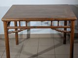 a wooden table with a brown top on a tiled floor