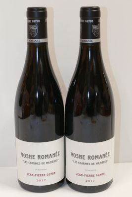 deux bouteilles de vin posées sur une table l'une à côté de l'autre