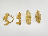 three pairs of gold earrings on a white surface