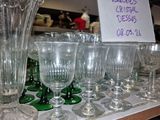 many glasses and vases on a shelf in a store