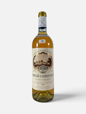 une bouteille de vin blanc posée sur une surface blanche