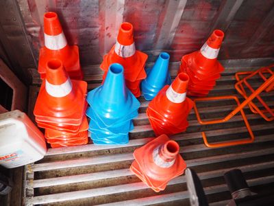 de nombreux cônes orange et bleus empilés à l'arrière d'un camion
