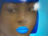 La femme porte une perruque bleue et du rouge à lèvres bleu.