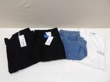 three pairs of black, white, and blue jeans sitting on a table