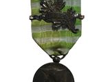 une vieille médaille représentant un cheval est suspendue à un ruban
