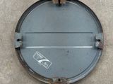 a close up of a metal lid on a concrete surface