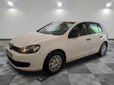 la volkswagen golf blanche est garée dans une pièce au sol en damier