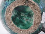 a close up of a green vase with writing on it