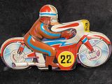 a tin toy of a man on a motorbike